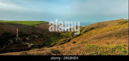 Vue panoramique de Kenidjack Valley dans l'ouest de Cornwall qui descend jusqu'à la mer à Porthledden Cove, à l'est du cap Cornwall, montrant le cap, le monument Heinz et les travaux miniers dans la vallée. Banque D'Images