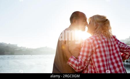 Histoire d'amour mature. Couple senior romantique s'embrassant à l'extérieur au coucher du soleil Banque D'Images