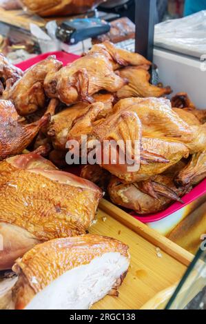 Du poulet fumé et d'autres délices fermiers se trouvent sur le comptoir. Les produits carnés sont prêts à être vendus à la foire. Banque D'Images