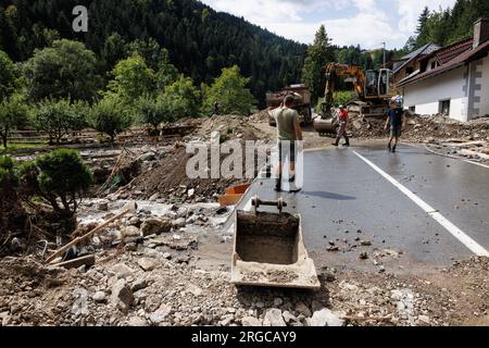 Raduha, Slovénie. 08 août 2023. Les gens nettoient les débris d’une route et d’une maison à Raduha, après que des inondations majeures ont frappé les deux tiers du pays il y a quelques jours. Des efforts de nettoyage et de sauvetage ont été réalisés après les inondations majeures en Slovénie. Certaines zones de la vallée de la rivière Savinja sont encore coupées du reste du monde. Les dégâts sont énormes. Crédit : SOPA Images Limited/Alamy Live News Banque D'Images