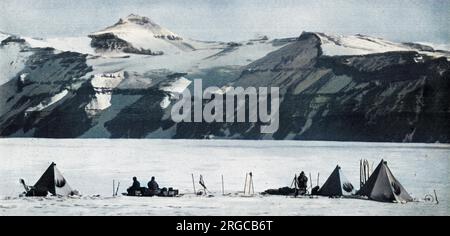 Photographie prise par le capitaine Scott lors de l'expédition polaire malheureuse au pôle Sud en 1910 - 1912, montrant des tentes dressées sur le chemin du glacier Beardmore, avec la chaîne Wild qui comprend les montagnes Adams, Marshall et Wild avec leur stratification horizontale formant la toile de fond. Banque D'Images