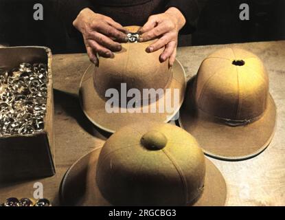 Fabrication de casques de type I pour l'Afrika Korps allemande - Seconde Guerre mondiale. Insertion du capuchon de ventilation sur le dessus du casque. Banque D'Images