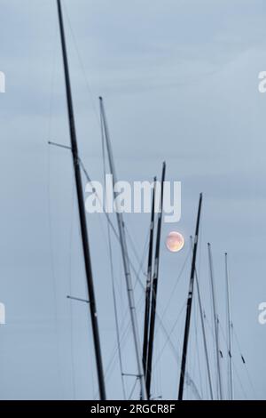 pleine lune sur de nombreux voiliers de match au crépuscule Banque D'Images