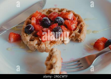 manger une gaufre garnie de baies Banque D'Images