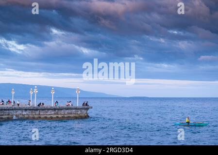 Dumaguete, Negros Island, Philippines-février 01 2023 : près de la digue de la mer l'homme, essayant d'attraper des poissons, jette des filets et attend, assis dans son petit bateau, Banque D'Images