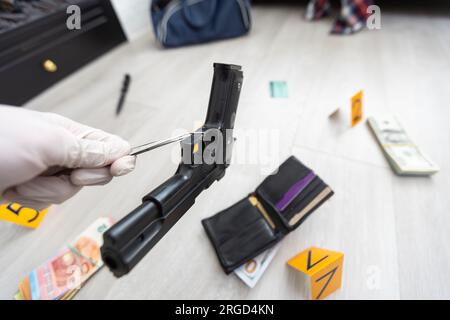 Détective dans des gants à la recherche de preuves, scène de crime Banque D'Images