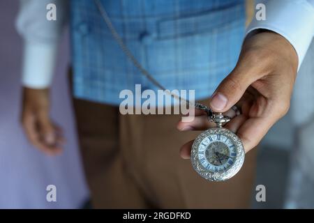 Homme tenant une précieuse montre de poche antique. Banque D'Images