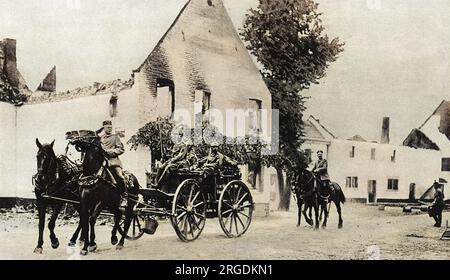 Les soldats allemands quittent le village belge de Mouland, derrière eux les cottages sans toit brûlés des résidents locaux. Banque D'Images