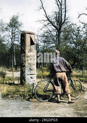 Un cycliste portant plus quatre, s'arrête pour lire l'inscription sur le cadran solaire monument au militant de l'heure d'été William Willet, Petts Wood, Chislehurst, Kent, Angleterre. Banque D'Images