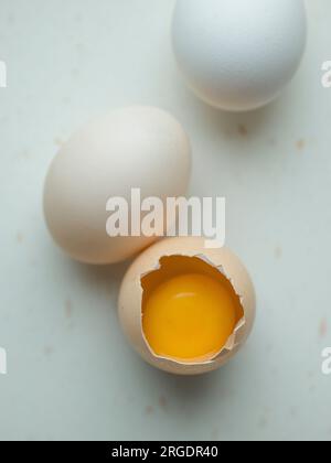 Gros plan, trois œufs de poule sur blanc, un ouvert Banque D'Images