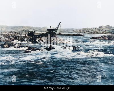 Construction du barrage d'Assouan (l'ancien barrage ou le barrage bas) sur le Nil en Égypte: Construction temporaire de la pierre et du sable dans le chenal central. Banque D'Images