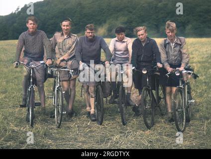 Six jeunes hommes sur leurs vélos dans un champ. Banque D'Images