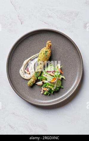 Fleur de courgette farcie, tahini labna, salade de concombre et radis Banque D'Images