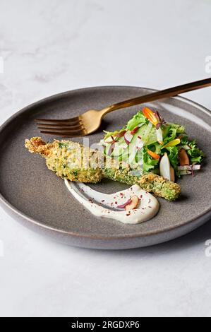Fleur de courgette farcie, tahini labna, salade de concombre et radis Banque D'Images