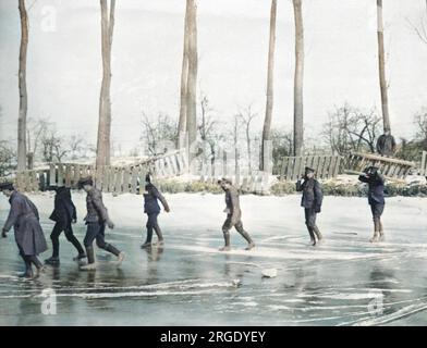 Un groupe de travail britannique transportant des plates-formes en bois à travers un canal gelé sur le front occidental pendant la première Guerre mondiale. Banque D'Images