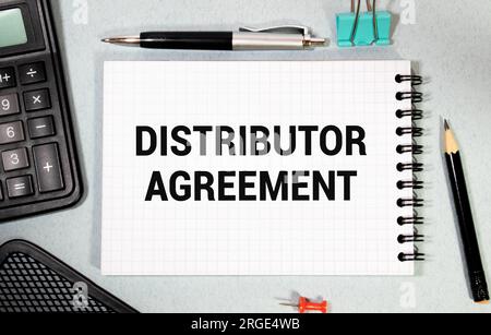 Sur une feuille de l'ACCORD DE DISTRIBUTEUR d'inscription de journal, à côté de lui est un crayon, des lunettes Banque D'Images