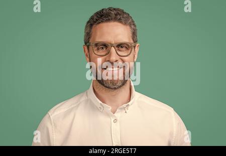 happy man look dans des lunettes isolées sur fond bleu. homme mûr regarde en lunettes en studio. Banque D'Images