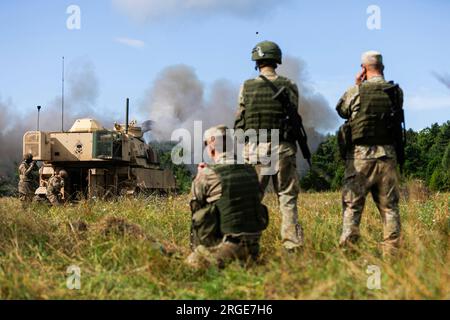 27 juillet 2023 - Klaipeda, Estonie - des soldats des forces terrestres lituaniennes observent un obusier automoteur Paladin M109A6 commandé par la batterie Charlie, 3e bataillon, 16e régiment d'artillerie de campagne, soutenant la 4e division d'infanterie, lors de l'exercice de tir réel Baltic Thunder près de Klaipeda, Lituanie, juillet 27. L’exercice multinational a permis aux alliés de l’OTAN de Lituanie et de Slovaquie de mener des missions de tir et de partager les meilleures pratiques. Le 4th Inf. La mission de Div. En Europe est de s'engager dans des entraînements et des exercices multinationaux à travers le continent, en travaillant aux côtés des alliés de l'OTAN et de l'ER Banque D'Images