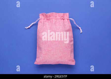 Sac en toile de jute rose sur fond bleu, vue de dessus Banque D'Images