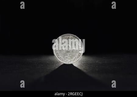 Image d'une pièce iranienne sur fond noir, avec un focus sur une pièce de 250 rians. Le rial est la monnaie officielle de l'Iran. Il est subdivisé int Banque D'Images