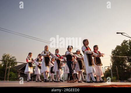 Photo d'un groupe d'enfants, d'enfants, de gens dansant un kolo serbe dans le village de Pecinci, en Serbie. Kolo est une danse circulaire slave du Sud, trouvé uedn Banque D'Images