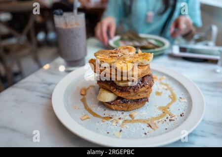 Crêpes à la banane et à l'avoine avec crème de noix de coco et top Chia. Banque D'Images