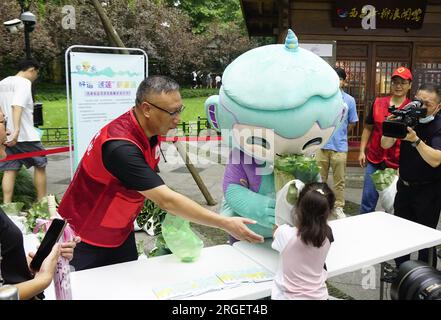 **CHINE CONTINENTALE, HONG KONG, MACAO ET TAIWAN OUT** les mascottes des Jeux asiatiques de Hangzhou aident à vendre des graines de lotus et des feuilles de lotus dans un ba caritatif Banque D'Images