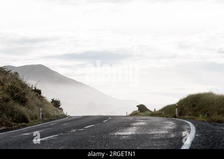 Un plan d'une route roulant sur les collines. La route s'éloigne dans une colline brumeuse et brumeuse Banque D'Images