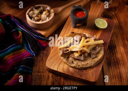 Taco de steak de bœuf avec frites. taco très populaire au mexique appelé taco de bistec ou carne asada, rôti de bœuf maison servi sur une tortilla de maïs. moi Banque D'Images