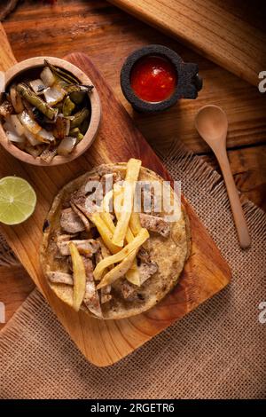 Taco de steak de bœuf avec frites. taco très populaire au mexique appelé taco de bistec ou carne asada, rôti de bœuf maison servi sur une tortilla de maïs. moi Banque D'Images