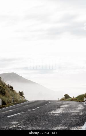 Un plan d'une route roulant sur les collines. La route s'éloigne dans une colline brumeuse et brumeuse Banque D'Images