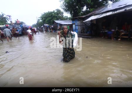 Chattogram. 9 août 2023. Une femme traverse une rue inondée à Chattogram, au Bangladesh, le 8 août 2023. Des jours de pluies torrentielles ont frappé la ville portuaire du Bangladesh, Chattogram, à quelque 242 km au sud-est de la capitale Dhaka, inondant les zones de faible altitude et perturbant la circulation routière, avec la plus forte averse enregistrée jusqu'à présent cette année lundi.Roads, les ruelles et les bylanes dans certaines parties de la première ville portuaire du pays sont allés sous la cheville jusqu'à l'eau des genoux, causant d'immenses difficultés aux navetteurs et à ses millions d'habitants. Crédit : Xinhua/Alamy Live News Banque D'Images