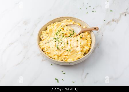 Oeufs maison tartinés avec oignon, bacon et ciboulette sur fond de marbre Banque D'Images