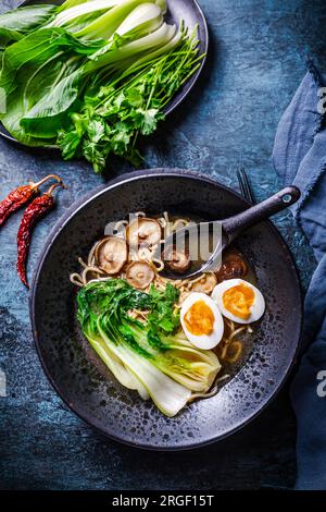 Soupe de nouilles asiatiques miso ramen avec shiitake, oeuf et pak choi chou sur fond sombre Banque D'Images