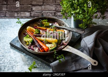 carottes arc-en-ciel rôties et brocolis dans une poêle vintage, style rustique Banque D'Images