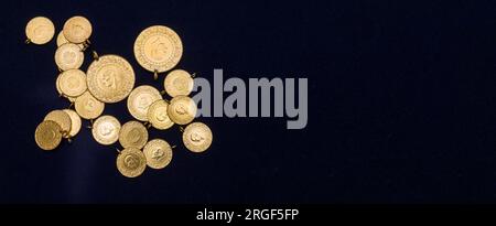Pile de pièces d'or turques pleines, demi et quart sur fond bleu marine foncé Banque D'Images