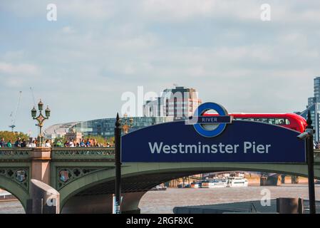 Panneau de jetée Westminster avec pont en arrière-plan à la capitale par temps nuageux Banque D'Images