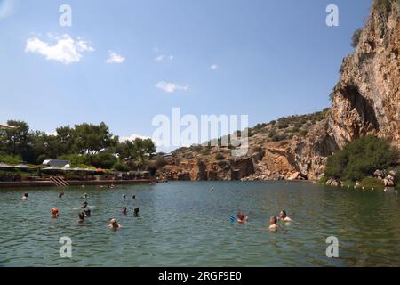 Vouliagmeni Athènes Grèce touristes nager dans le lac Vouliagmeni un Spa naturel - était une fois une caverne, mais le toit de la grotte est tombé en raison de l'érosion de la Banque D'Images