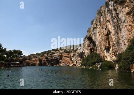 Vouliagmeni Athènes Grèce touristes nager dans le lac Vouliagmeni un Spa naturel - était une fois une caverne, mais le toit de la grotte est tombé en raison de l'érosion de la Banque D'Images