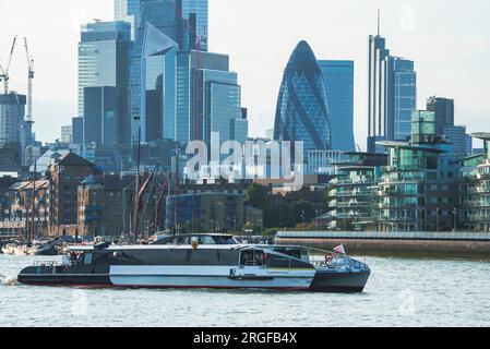 Tourboat sur la tamise, Skyline du quartier finanial en arrière-plan Banque D'Images