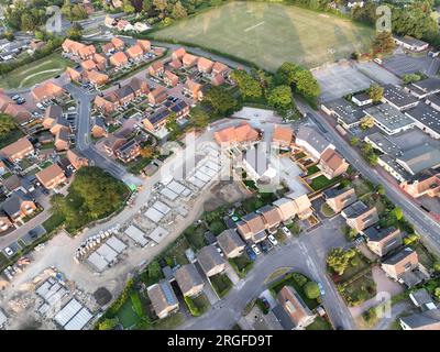 Vue aérienne regardant sur une zone de construction de logements neufs sur le bord des maisons existantes et des champs verts Banque D'Images