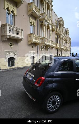 Vue panoramique d'une Fiat 500 classique garée devant le luxueux hôtel quatre étoiles Excelsior Palace sur Viale Pietro Toselli à Taormina Sicile, Italie. Banque D'Images