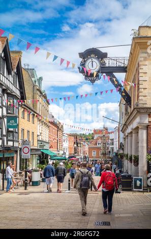 Une vue vers l'ouest sur la High Street dans la ville historique de Winchester, Hampshire, Royaume-Uni à côté de God Begot House et sous l'emblématique horloge victorienne en fer. WiNC Banque D'Images