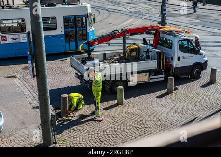 Gothenburg, Suède - avril 20 2016 : deux ouvriers réparent des pavés dans la rue. Banque D'Images