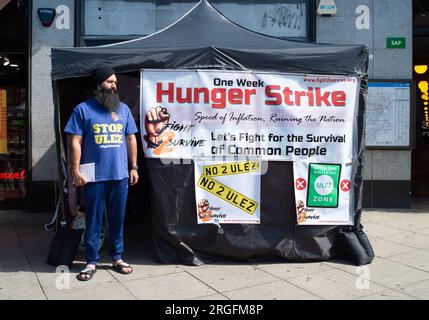 Uxbridge, Royaume-Uni. 9 août 2023. Le chauffeur de taxi Prabhdeep Singh est au quatrième jour d'une grève de la faim de sept jours devant la station de métro Uxbridge dans le quartier londonien de Hillingdon. Il proteste contre la nouvelle zone d’ultra-faible émission (ULEZ) qui entrera en vigueur à la fin de ce mois dans l’ouest de Londres. M. Singh, qui fait partie des campagnes Stop ULEZ et Fight2Survive, est un chauffeur de taxi basé à Reading qui dépose souvent ses passagers à Londres Heathrow (LHR). À partir de la fin août, le LHR fera maintenant partie de la zone à ultra-faibles émissions élargie qui est mise en place par Transports Banque D'Images