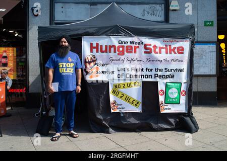 Uxbridge, Royaume-Uni. 9 août 2023. Le chauffeur de taxi Prabhdeep Singh est au quatrième jour d'une grève de la faim de sept jours devant la station de métro Uxbridge dans le quartier londonien de Hillingdon. Il proteste contre la nouvelle zone d’ultra-faible émission (ULEZ) qui entrera en vigueur à la fin de ce mois dans l’ouest de Londres. M. Singh, qui fait partie des campagnes Stop ULEZ et Fight2Survive, est un chauffeur de taxi basé à Reading qui dépose souvent ses passagers à Londres Heathrow (LHR). À partir de la fin août, le LHR fera maintenant partie de la zone à ultra-faibles émissions élargie qui est mise en place par Transports Banque D'Images