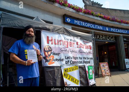 Uxbridge, Royaume-Uni. 9 août 2023. Le chauffeur de taxi Prabhdeep Singh est au quatrième jour d'une grève de la faim de sept jours devant la station de métro Uxbridge dans le quartier londonien de Hillingdon. Il proteste contre la nouvelle zone d’ultra-faible émission (ULEZ) qui entrera en vigueur à la fin de ce mois dans l’ouest de Londres. M. Singh, qui fait partie des campagnes Stop ULEZ et Fight2Survive, est un chauffeur de taxi basé à Reading qui dépose souvent ses passagers à Londres Heathrow (LHR). À partir de la fin août, le LHR fera maintenant partie de la zone à ultra-faibles émissions élargie qui est mise en place par Transports Banque D'Images