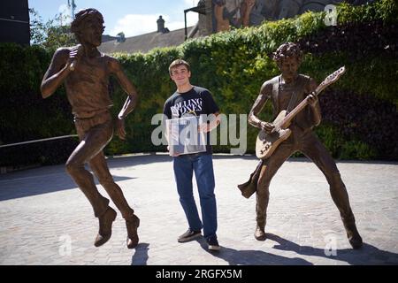 Kian Hunter âgé de 9 ans de Dartford tenant un premier presseur de l'album Sticky Fingers tout en posant à côté de "The Glimmer Twins", une statue de Rolling Stones Sir Mick Jagger et Keith Richards créée par la sculptrice Amy Goodman, lors de son dévoilement au One Bell Corner à Dartford, Essex. La statue a été commandée par le conseil municipal de Dartford pour célébrer deux des anciens résidents les plus célèbres de la ville. Date de la photo : mercredi 9 août 2023. Banque D'Images