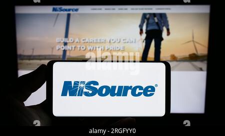 Personne tenant un smartphone avec le logo de la société de services publics américaine NiSource Inc. Sur l'écran devant le site Web. Concentrez-vous sur l'affichage du téléphone. Banque D'Images