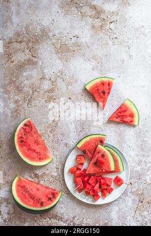 Tranché et chunky pastèque fraîche sur une assiette sur un fond beige texturé, vue de dessus avec espace de copie Banque D'Images